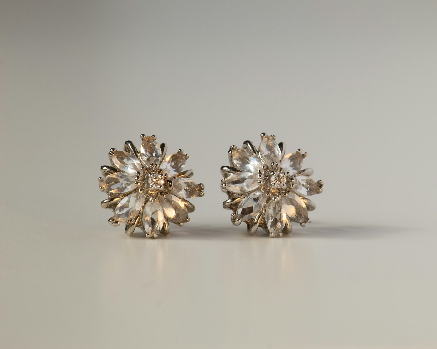 Faceted crystal cluster stud earrings on a neutral surface